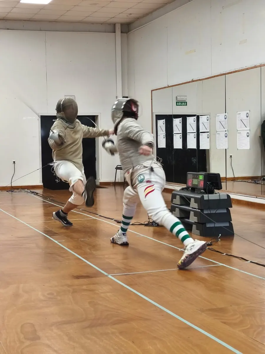 Dos esgrimistas de sable en un asalto de entrenamiento en la sala del club