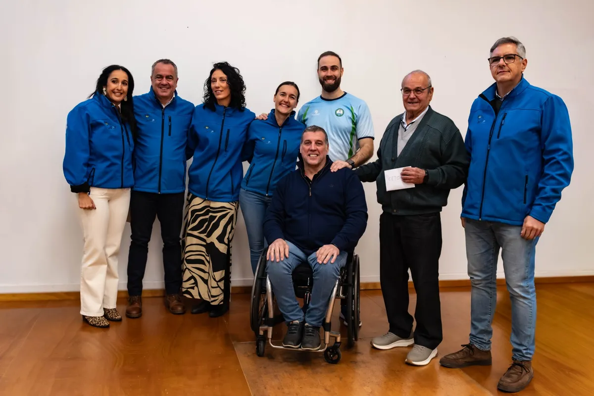 Grupo de adultos sonriendo junto a un esgrimista en silla de ruedas en el Torneo de Navidad del club en Torremolinos